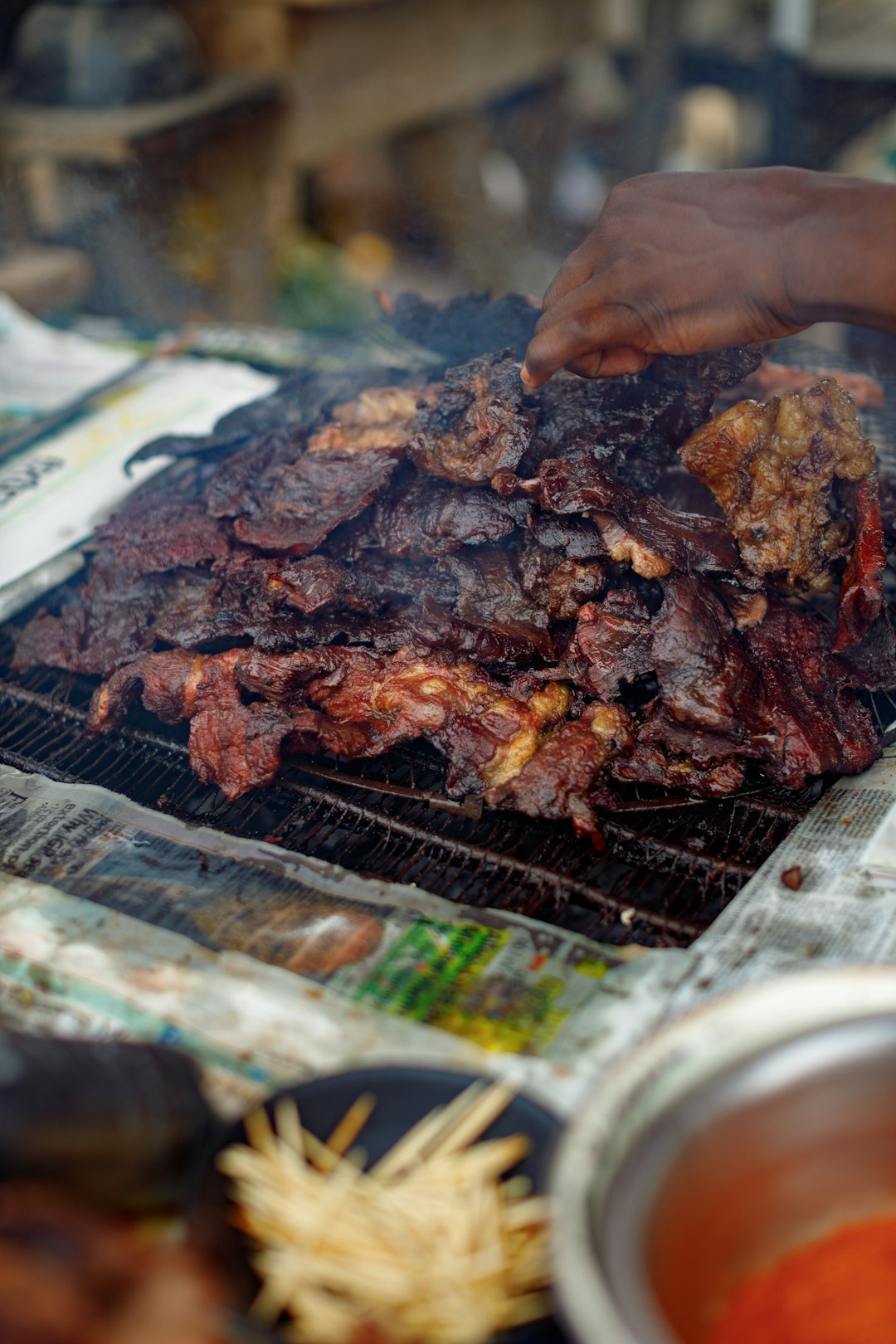 a-hand-flips-grilled-meat-over-an-open-fire-ylxxckegf5k